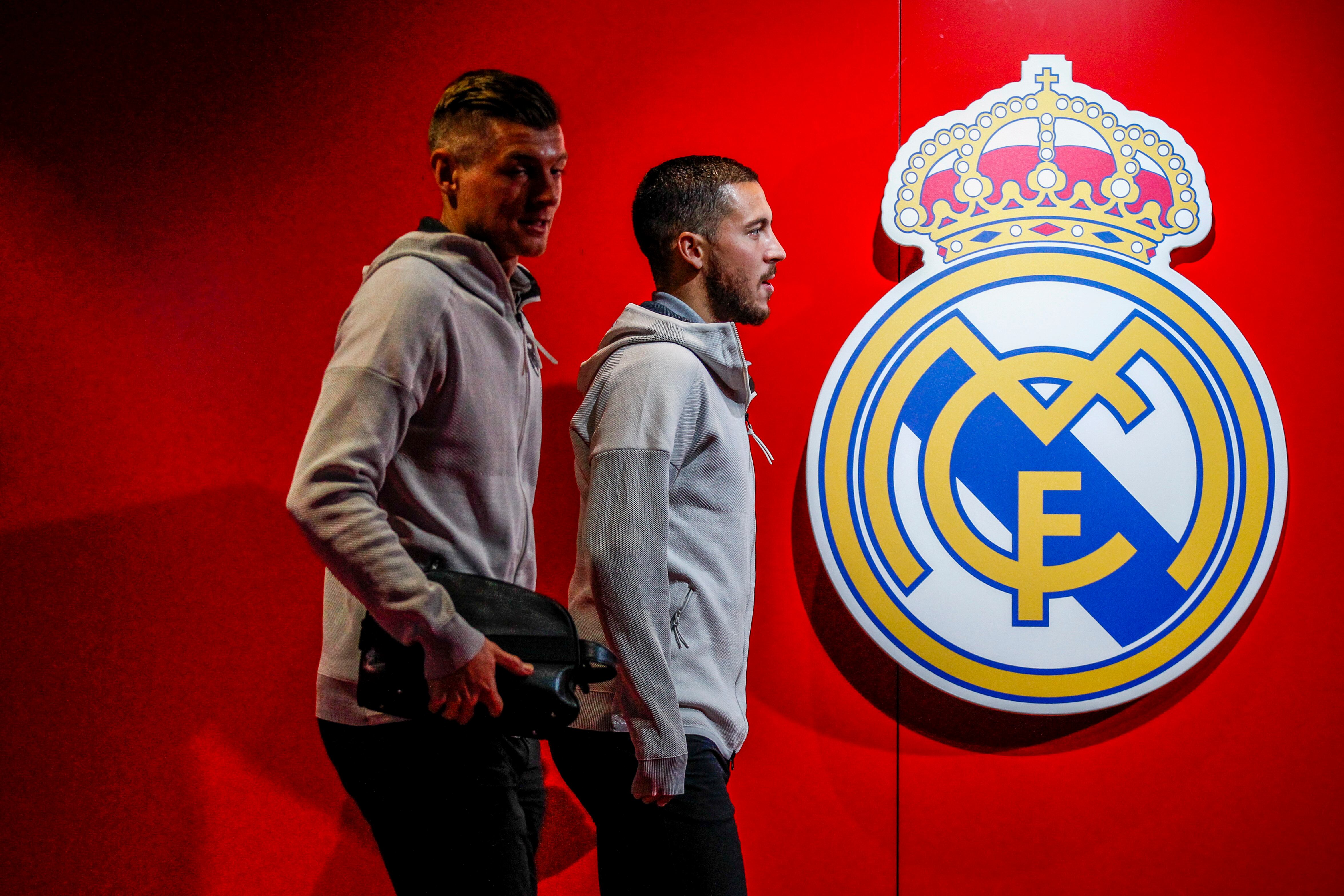 Toni Kroos y Eden Hazard pasean por un pasillo con el escudo del Real Madrid