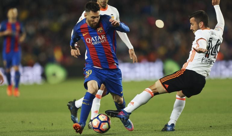 El delantero argentino del FC Barcelona, Lionel Andrés Messi (i) y el defensa del Valencia José Luis Gayá durante el partido de la vigésimo octava jornada de Liga en Primera División 