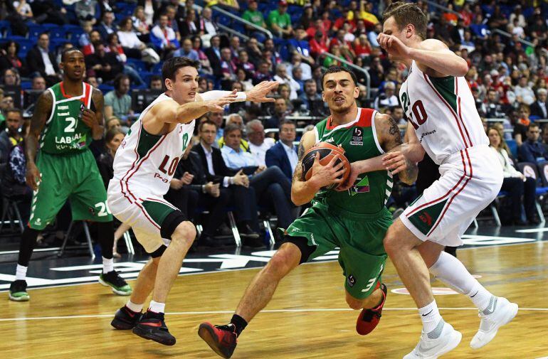 Mike James intenta penetrar a canasta ante la defensa de dos jugadores del Lokomotiv Kuban.