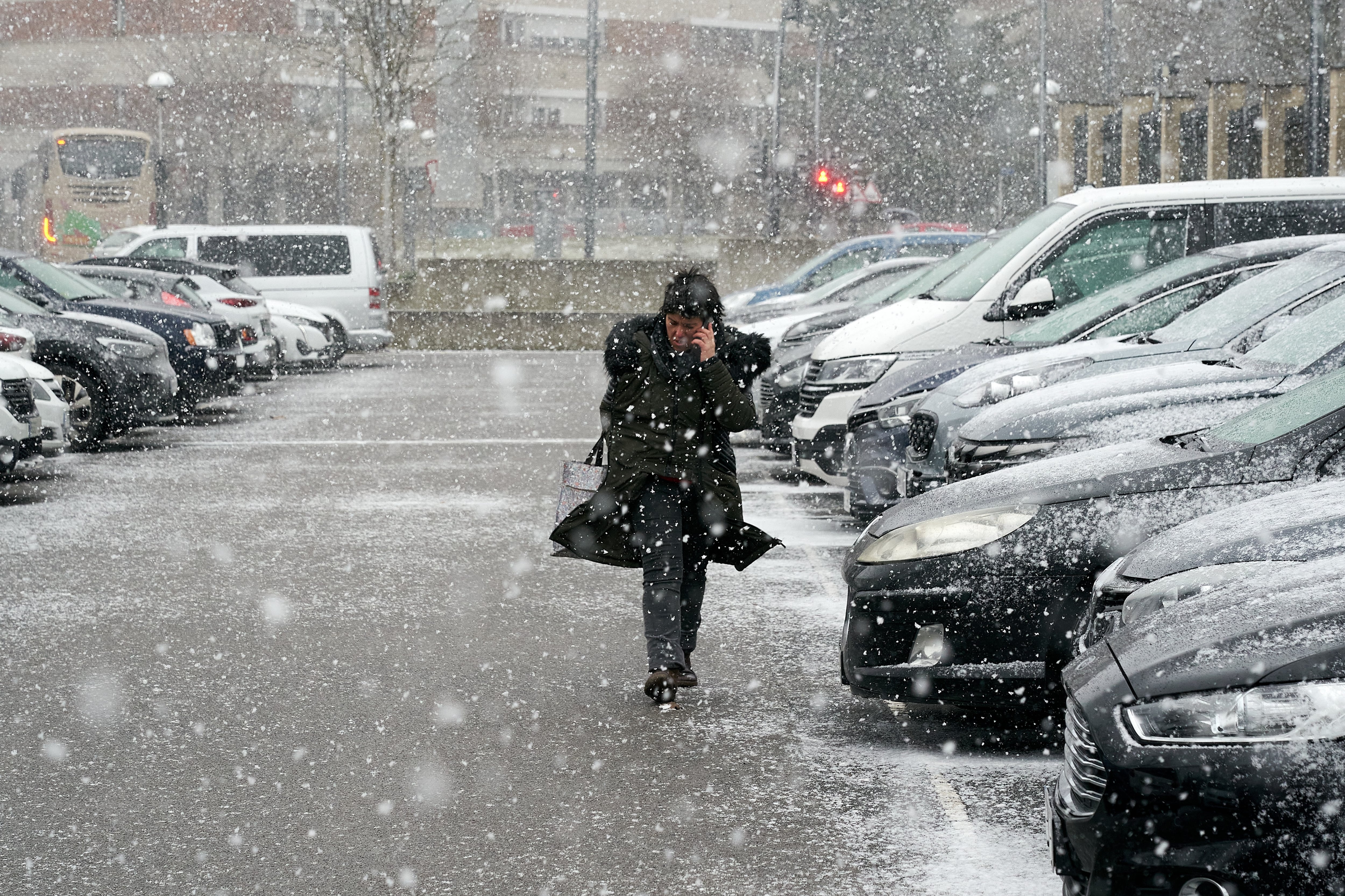 Una mujer camina este lunes por las calles de Vitoria bajo una intensa nevada.