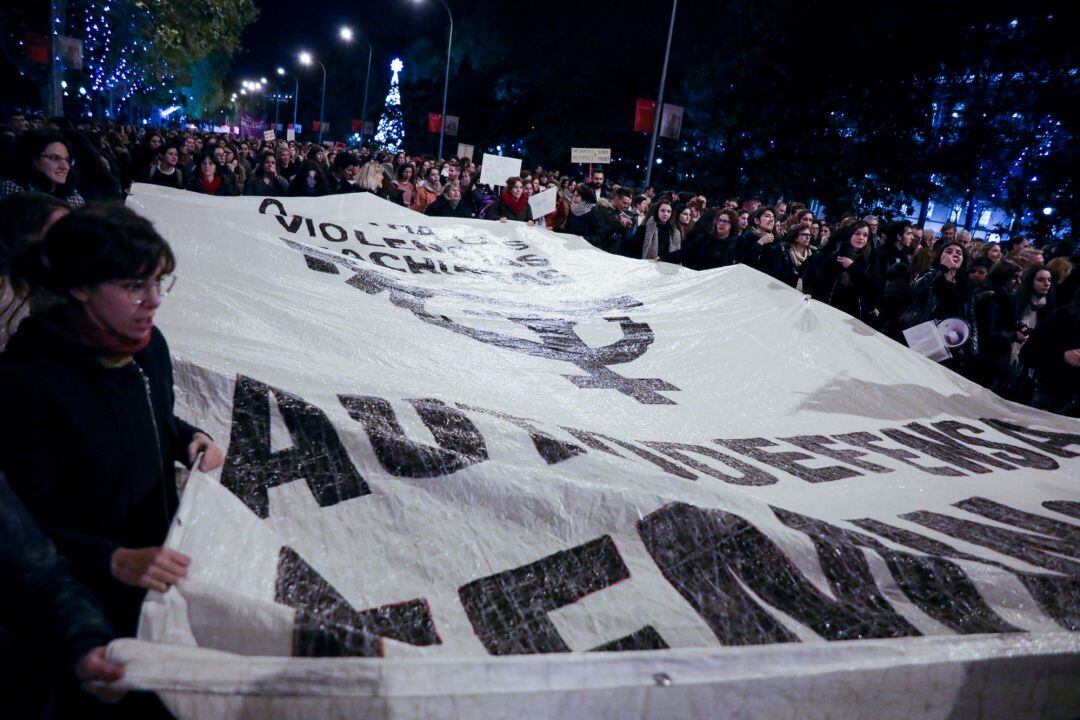 Varias mujeres sostienen una pancarta gigante en la que se ve un símbolo feminista con un puño en alto, en la manifestación en Madrid