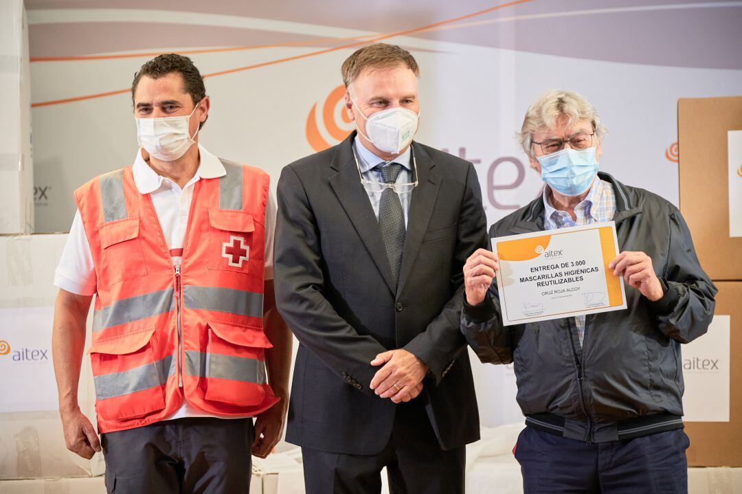 El presidente de AITEX, Rafael Pascual, junto a los representantes de Cruz Roja, Luis Llorens y Pablo Granados