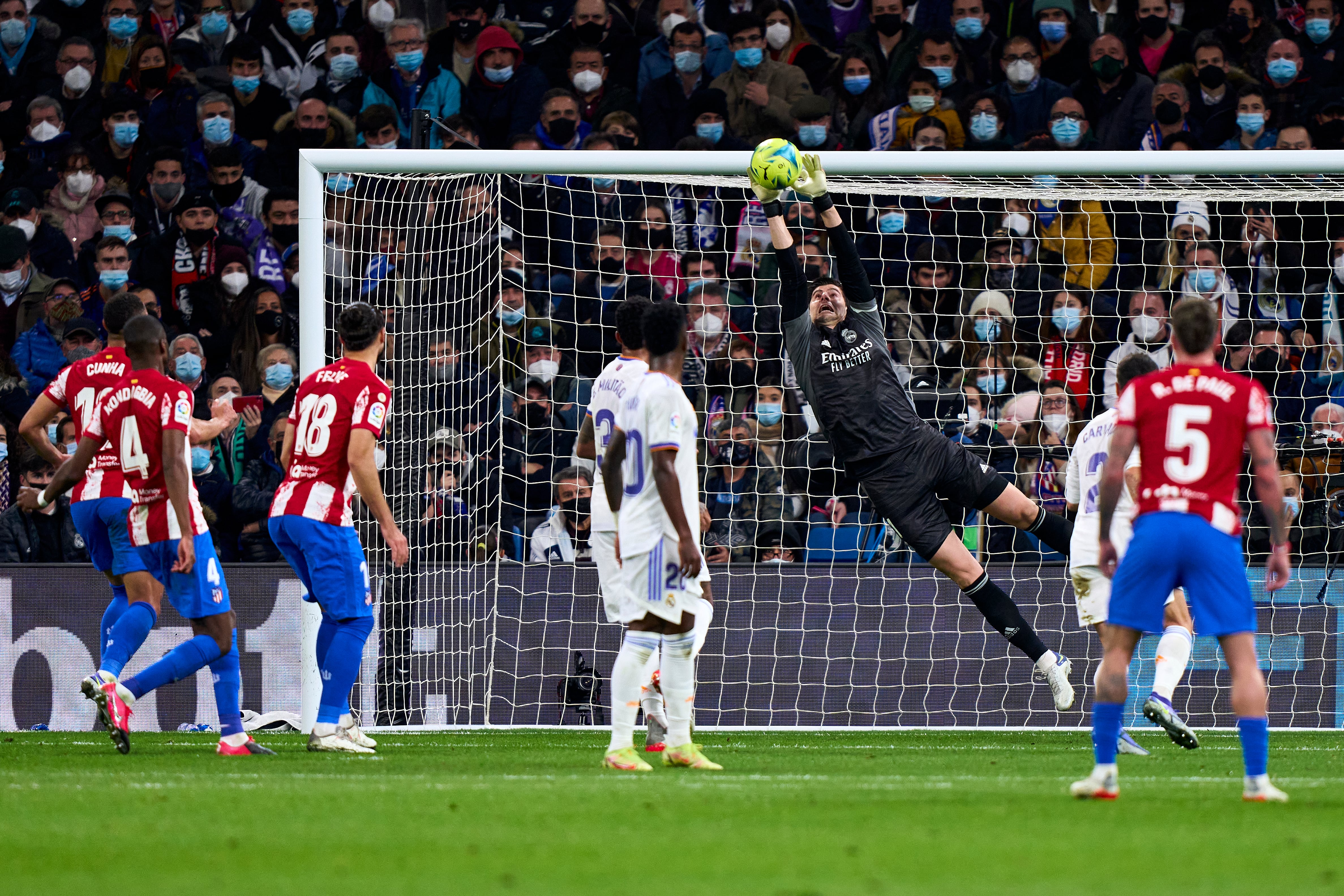 Courtois parando un balón en un encuentro del Real Madrid ante el Atlético de Madrid.