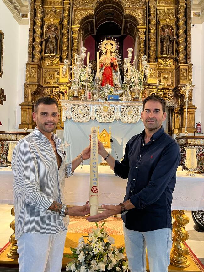 Colocación del cirio 'Consuelo de Vida' en el paso de la Virgen de Consolación de Osuna