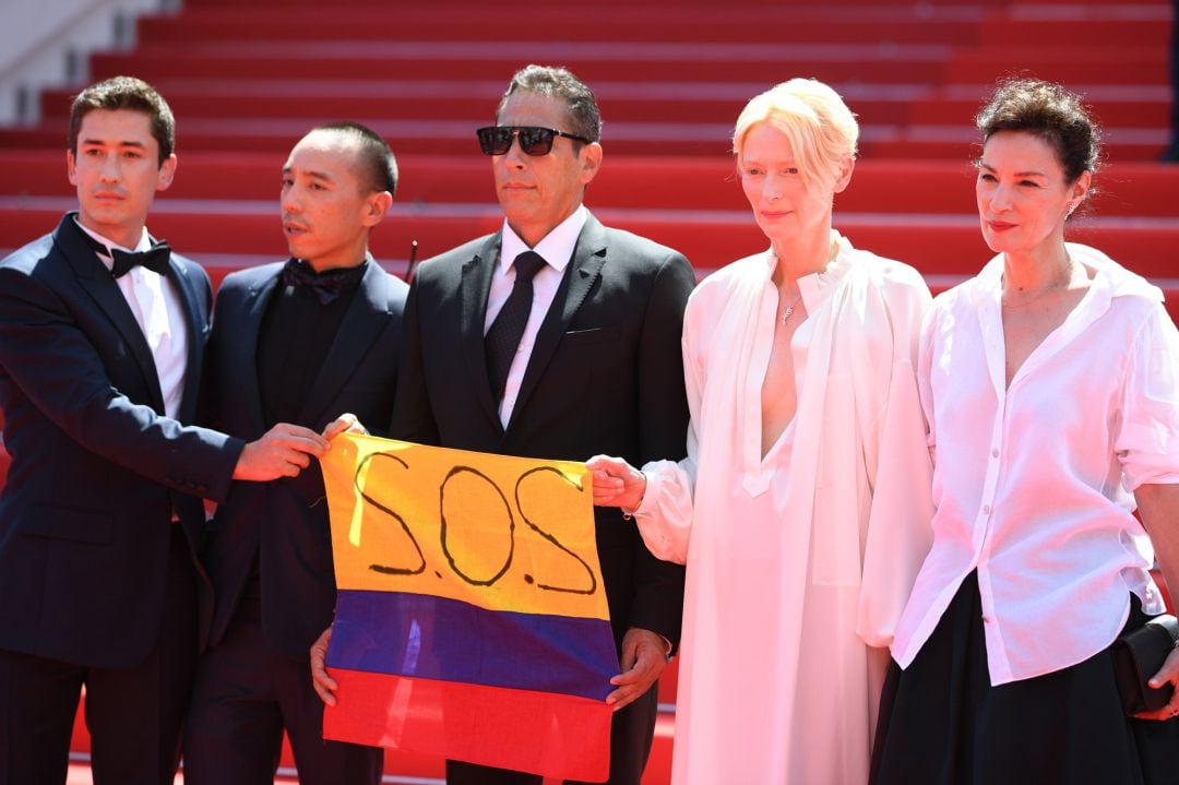 CANNES, FRANCE - JULY 15: (L-R) Juan Pablo Urrego, Apichatpong Weerasethakul, Elkin Diaz, Tilda Swinton and Jeanne Balibar show the Colombian flag with the S.O.S sign as they attend the &quot;Memoria&quot; screening during the 74th annual Cannes Film Festival on July 15, 2021 in Cannes