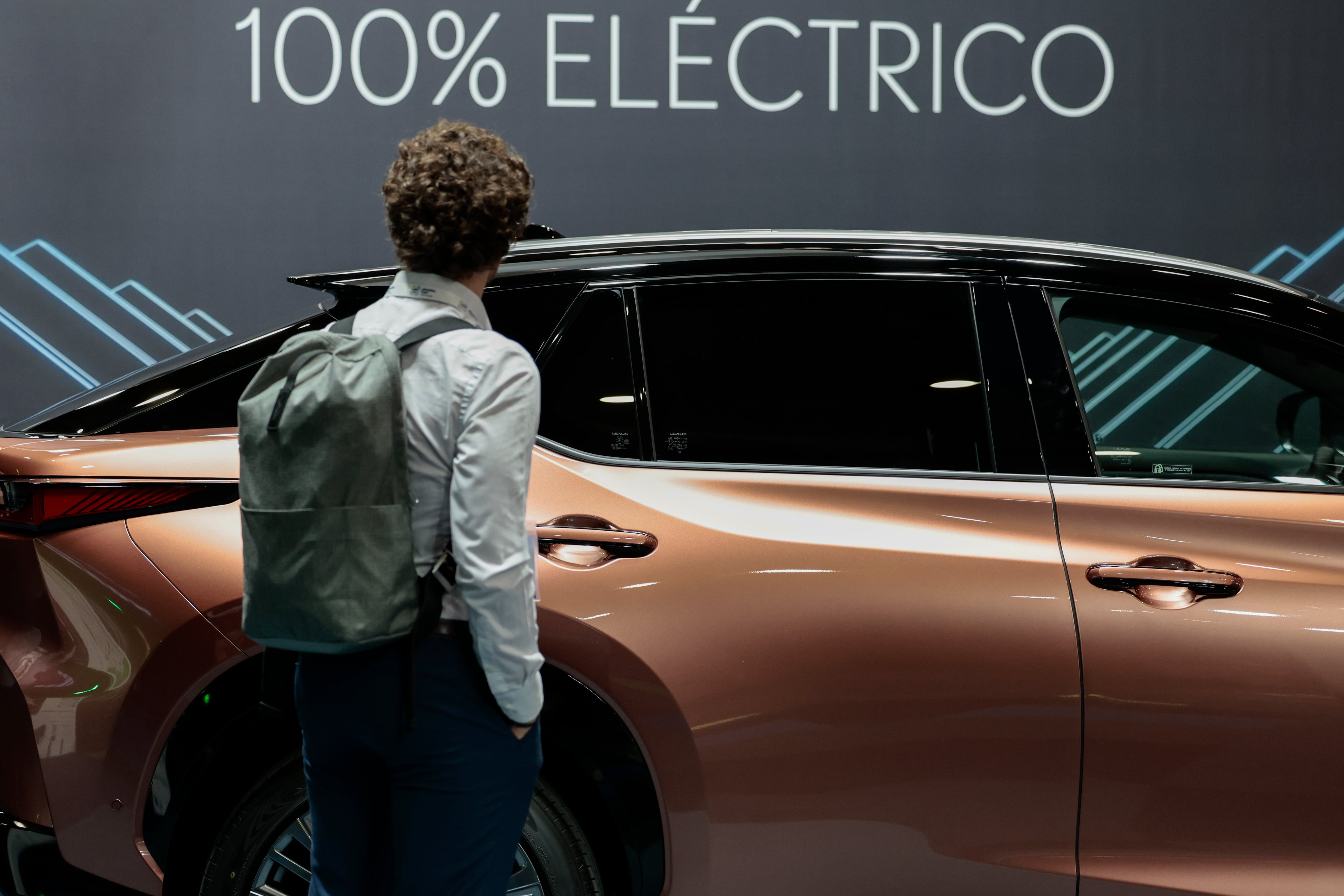 Una persona contempla un coche eléctrico