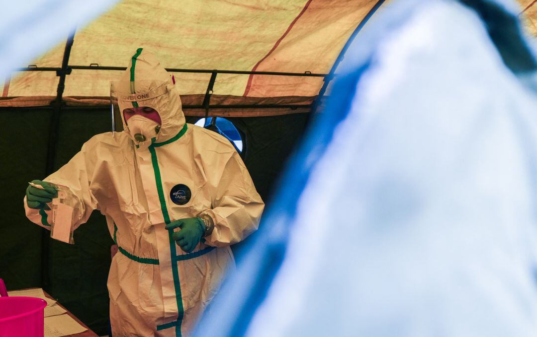  A health worker wears a protective suit, mask and gloves as carries a PCR Coronavirus test
