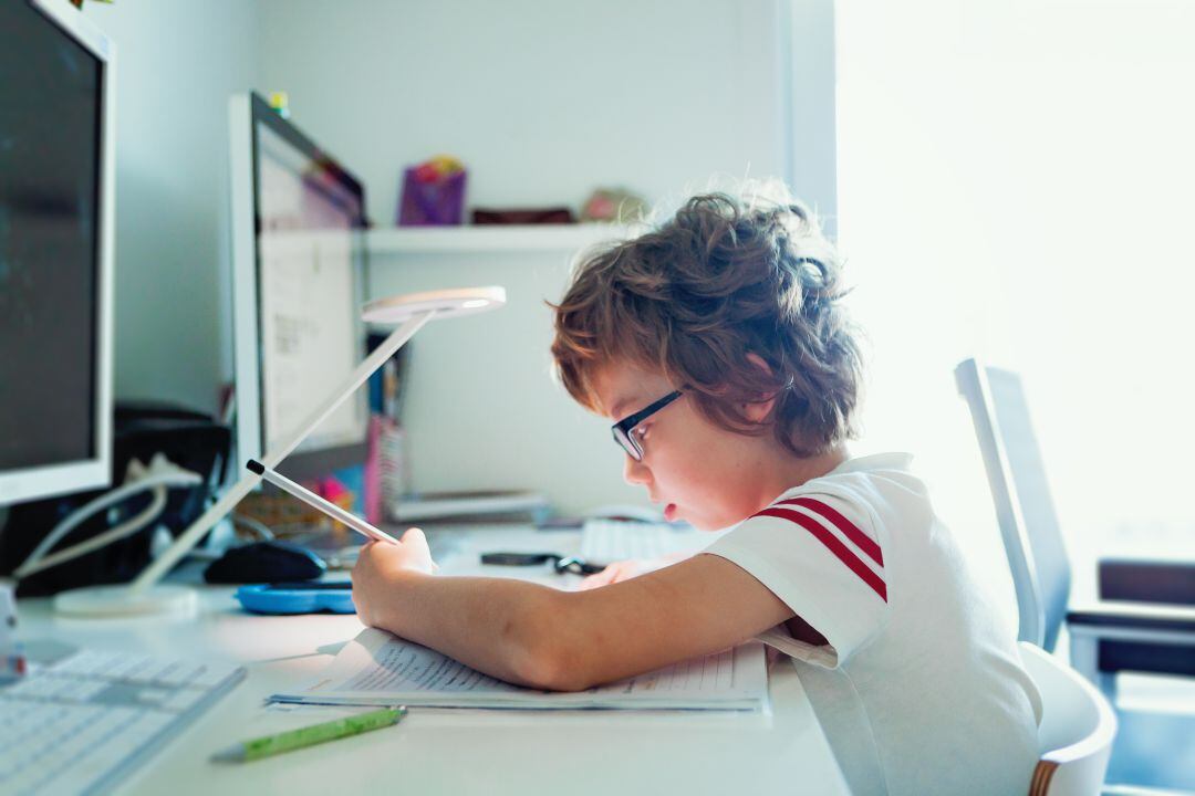 Un menor estudiando en su habitación. 