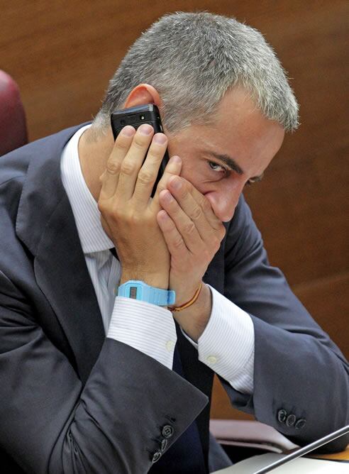 El diputado popular Ricardo Costa habla por teléfono esta mañana durante el pleno extraordinario que se ha celebrado en Les Corts sobre el proyecto ferroviario del Corredor Mediterráneo