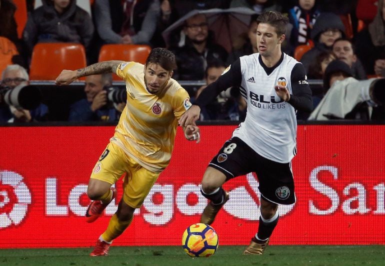 GRAF349. VALENCIA (ESPAÑA), El delantero argentino del Valencia,Luciano Vietto (d), lucha por el balón con el delantero del Girona, Portu (i), durante el partido de la 18ª jornada de Liga que los dos equipos disputan esta tarde en el estadio de Mestalla. 