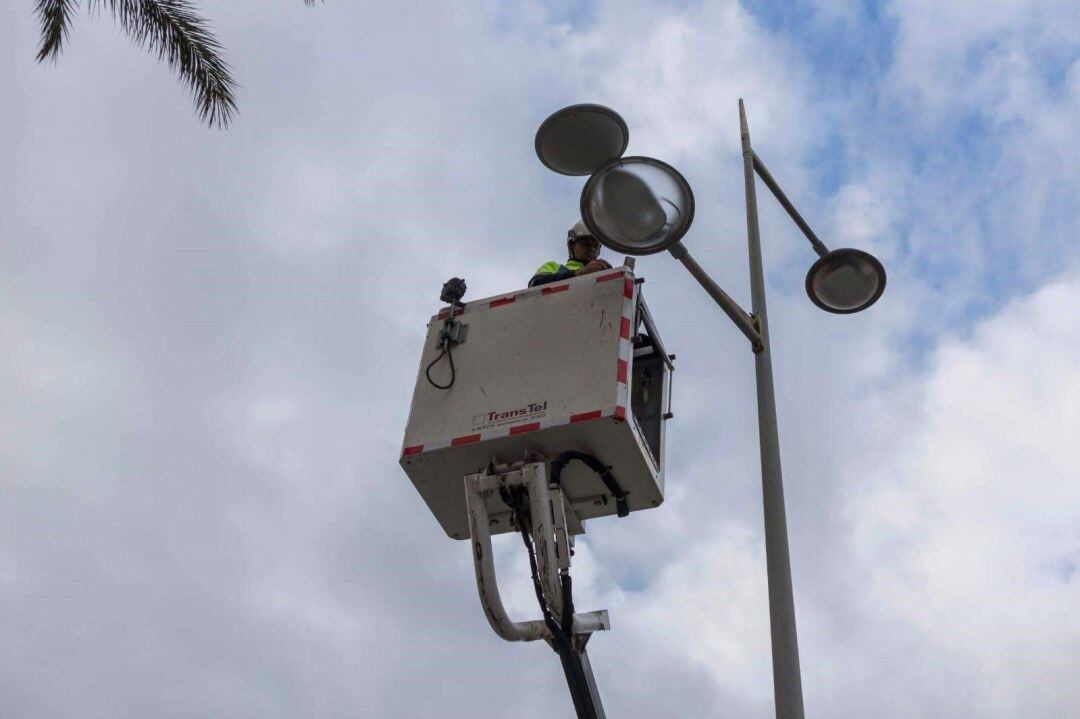 Un operario repara una luminaria.