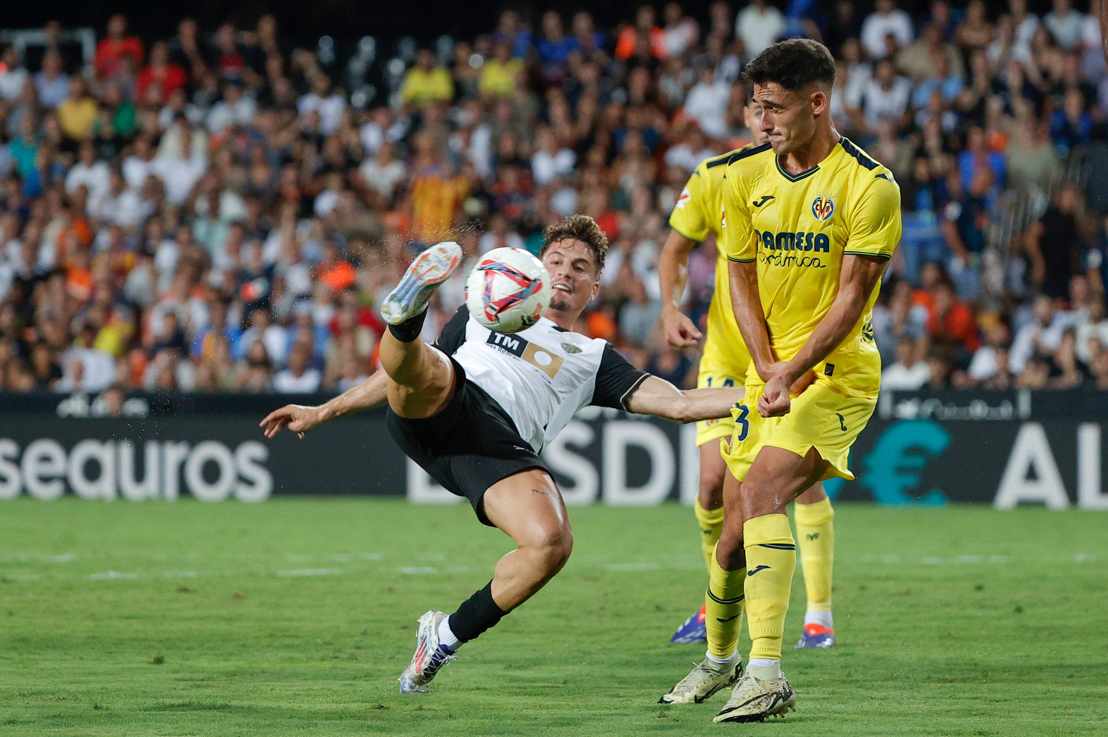 VALENCIA 31/08/2024.- El centrocampista del Valencia Sergi Canos (i) intenta rematar ante Sergi Cardona, del Villarreal, durante el encuentro de la cuarta jornada de LaLiga entre el Valencia CF y el Villarreal, este sábado en el estadio de Mestalla, Valencia. EFE/ Manuel Bruque
