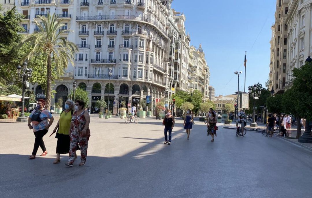 Varias personas caminando por la plaza del Ayuntamiento de València.