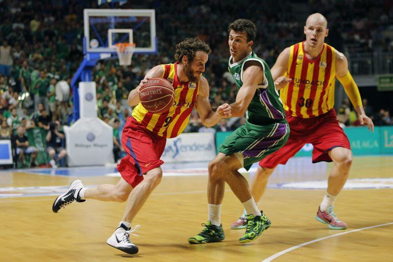 El escolta estadounidense de Unicaja Ryan Toolson defiende la internada del brasileño Marcelinho Huertas