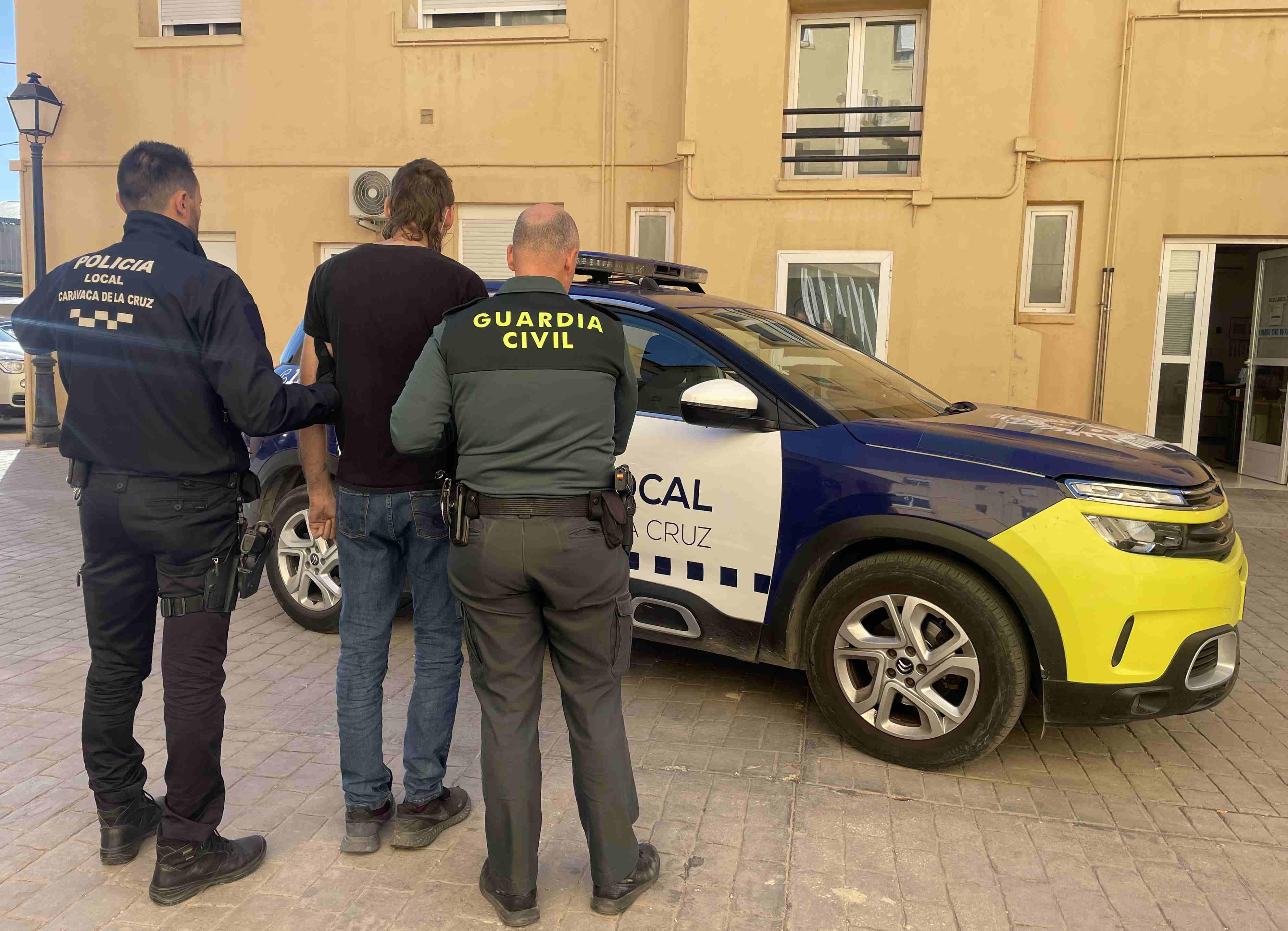 Uno de los detenidos en la operación policial trasladado por agentes de Guardia Civil y Policía Local