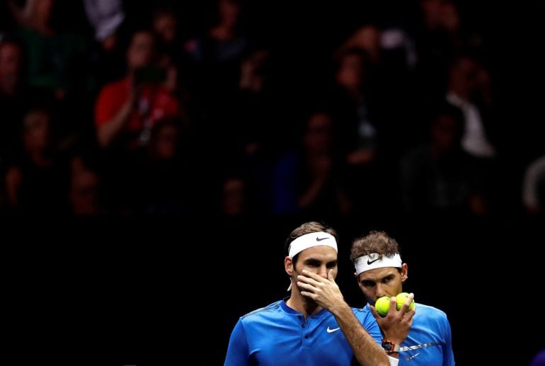 Federer y Nadal charlan durante el partido de dobles que disputaron ante Sock y Querrey