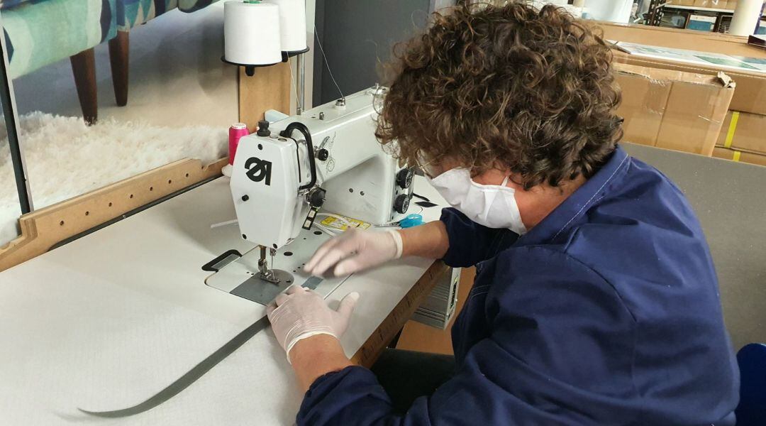 Una trabajadora cosiendo una mascarilla