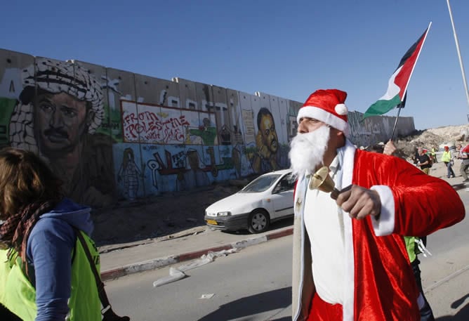 Un palestino vestido de Santa Claus en la protesta en el puesto de control de Qalandiya del muro israelí