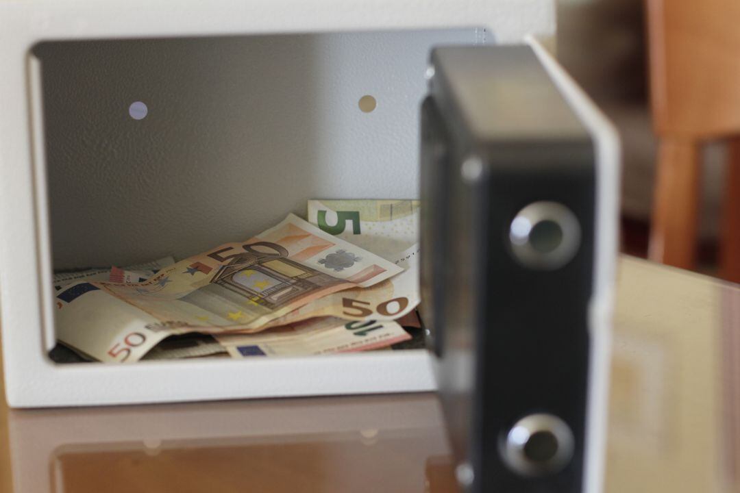 Caja fuerte abierta con dinero en su interior.