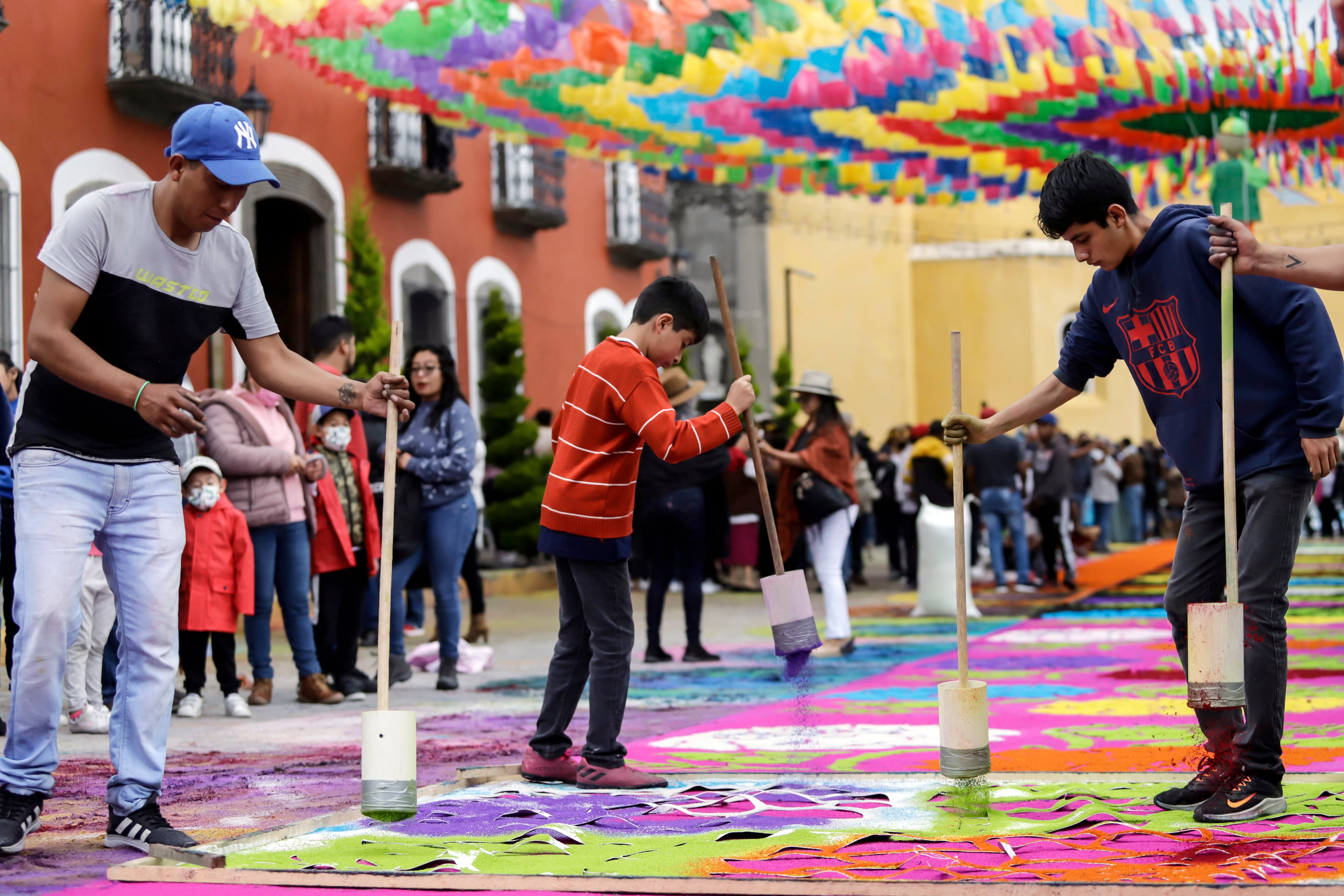 Un grupo de artesanos elaboran alfombras de colores de aserrín en la &quot;Noche que Nadie Duerme&quot;.