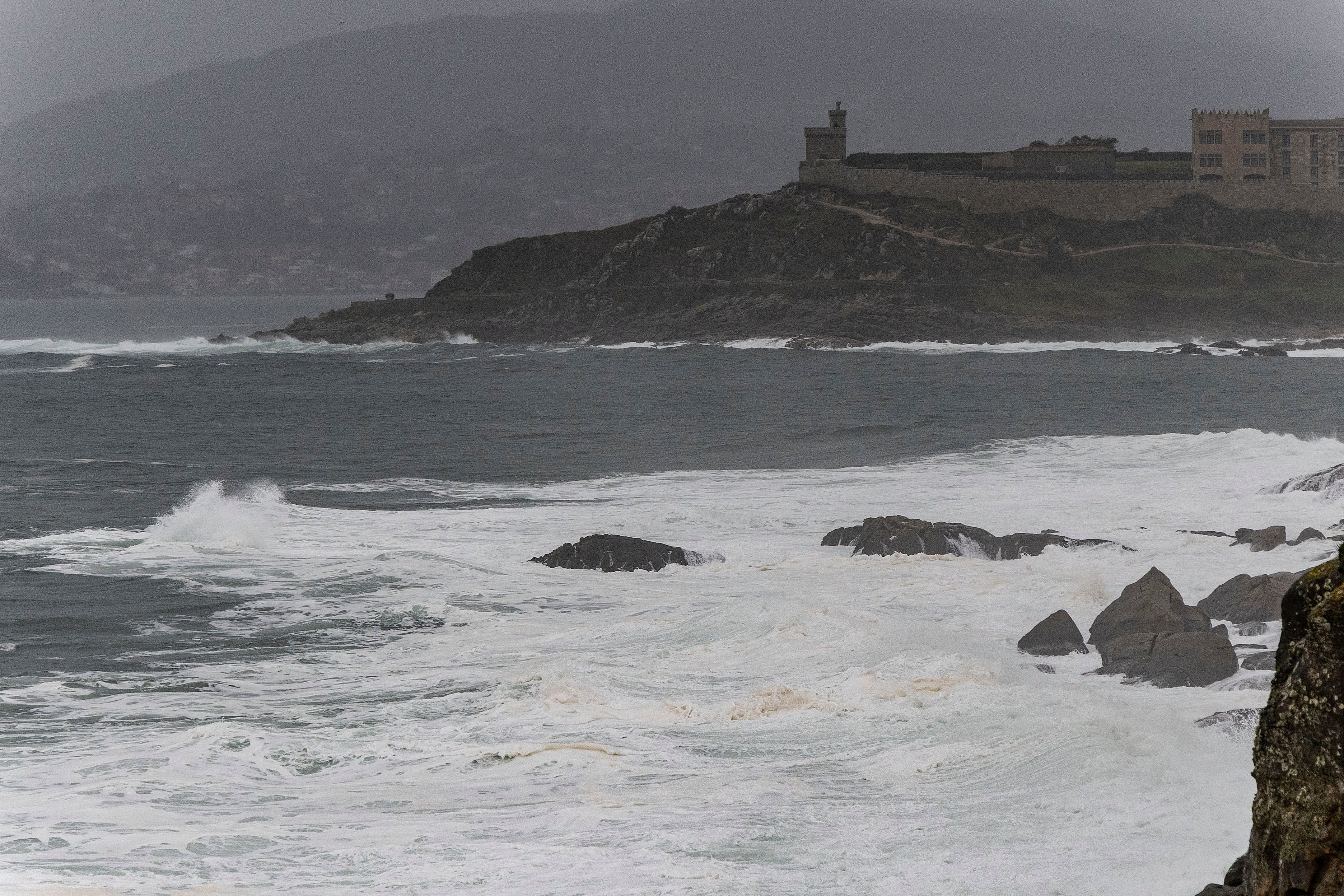 BAIONA, 12/11/2025.- Vista del mar revuelto tomada desde el paseo marítimo de Baiona con el Parador Nacional al fondo, este miércoles. Galicia, Canarias, Asturias y Cantabria están en alerta naranja (riesgo importante) por tormentas, lluvias, viento y/o temporal marítimo con olas de hasta 6 metros en el litoral gallego, a las que se suman Castilla y León y Navarra, en nivel amarillo de alerta, por rachas fuertes y riesgo para ciertas actividades. EFE/ Salvador Sas