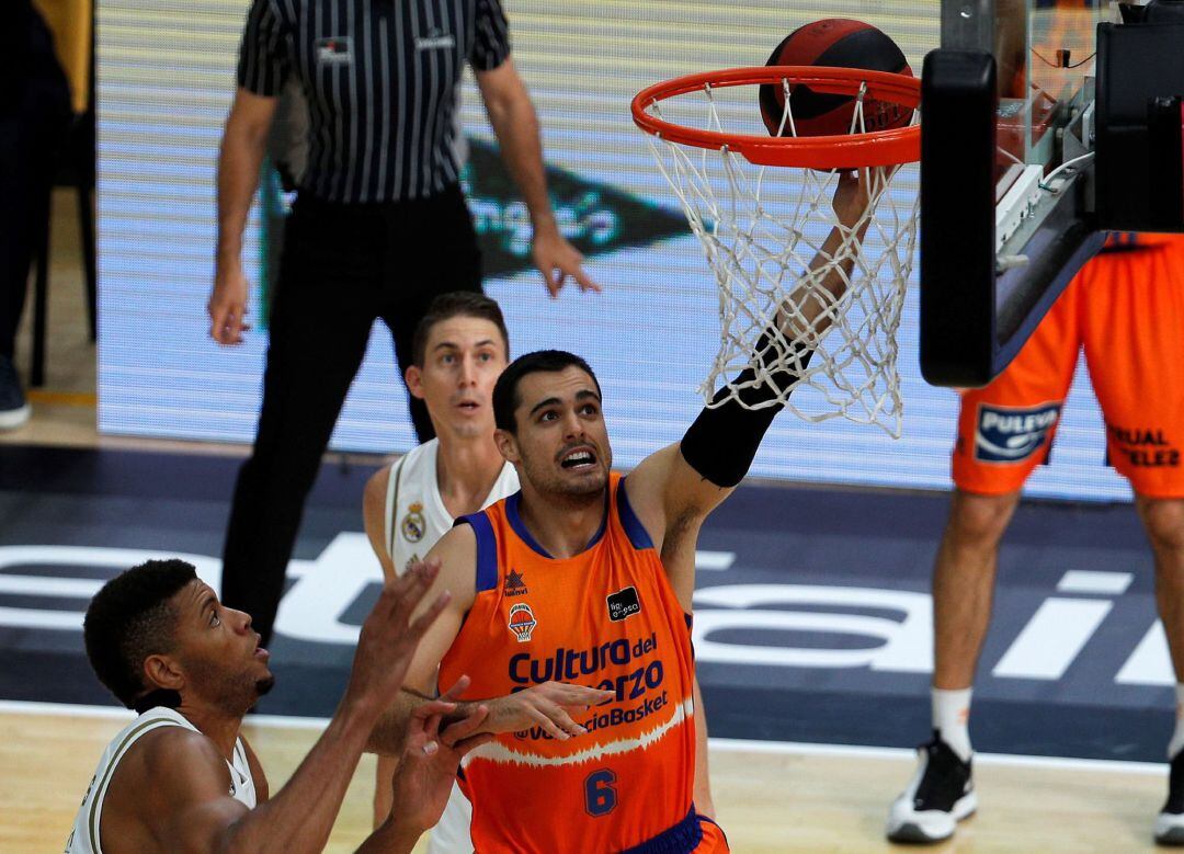 GRAFCVA6189. VALENCIA, El alero del Valencia Basket, Alberto Abalde, entra a canasta ante el pívot caboverdiano del Real Madrid, Walter Tavares, durante la disputa del segundo partido de la tercera jornada del grupo B de la fase final de la Liga Endesa en el pabellón de la Fuente de San Luis de Valéncia. EFE, Manuel Bruque