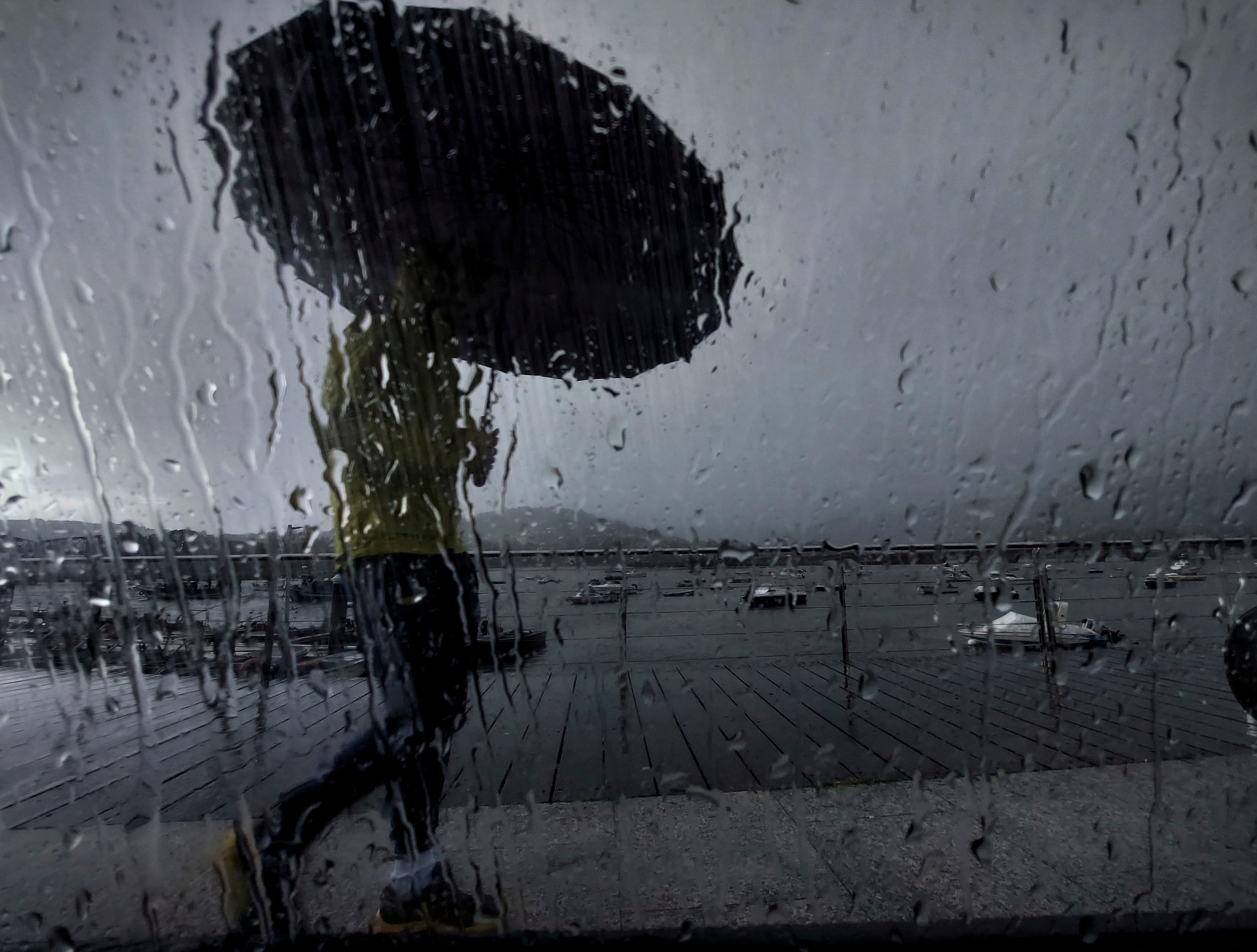 -FOTODELDIA- PONTEDEUME (A CORUÑA), 30/10/2023.- Un hombre con paraguas camina este lunes por el puerto de Pontedeume, en una jornada marcada nuevamente por las lluvias. EFE/ Cabalar
