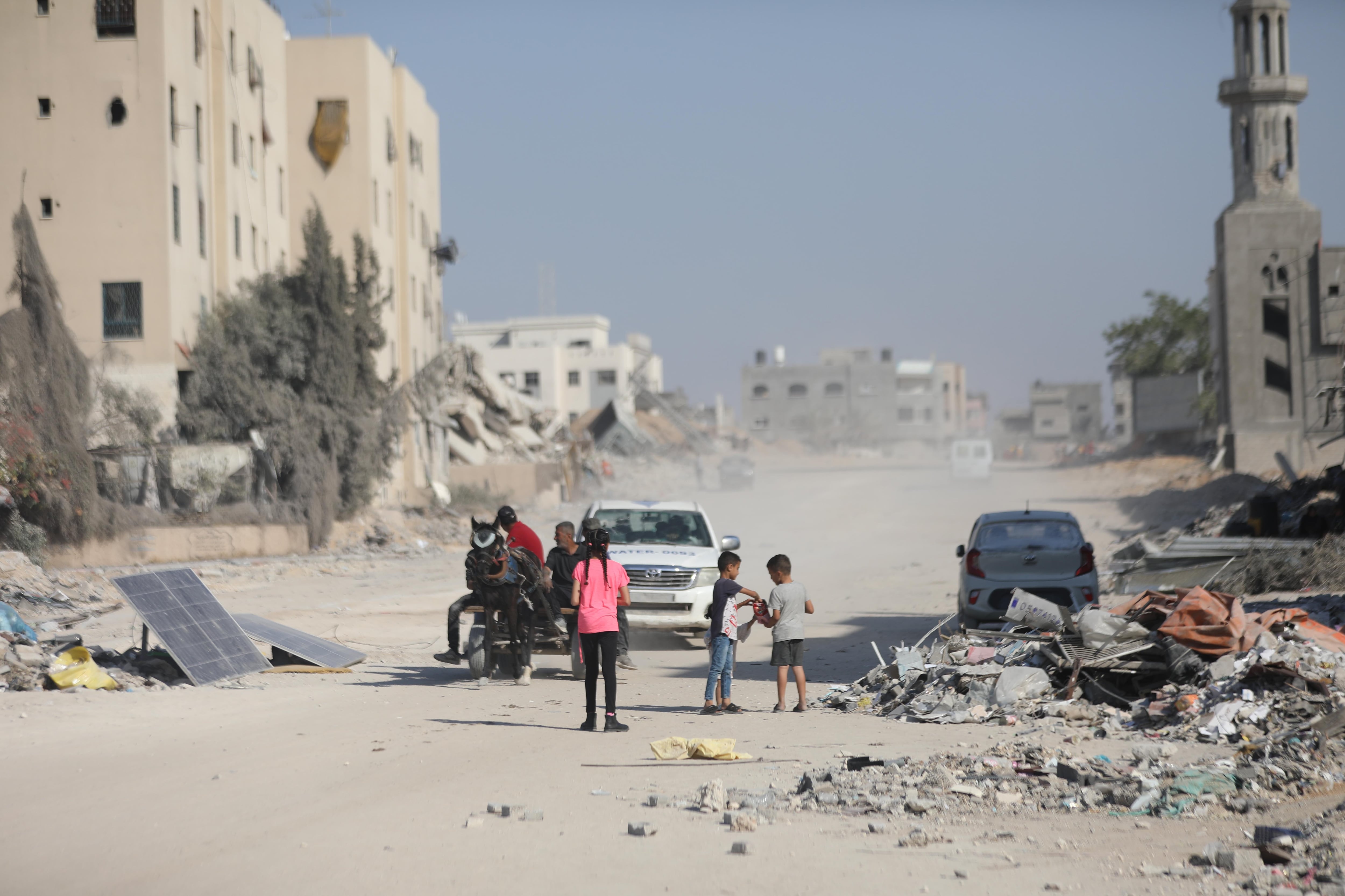 Varios niños palestinos rodeados de escombros en la ciudad de Gaza