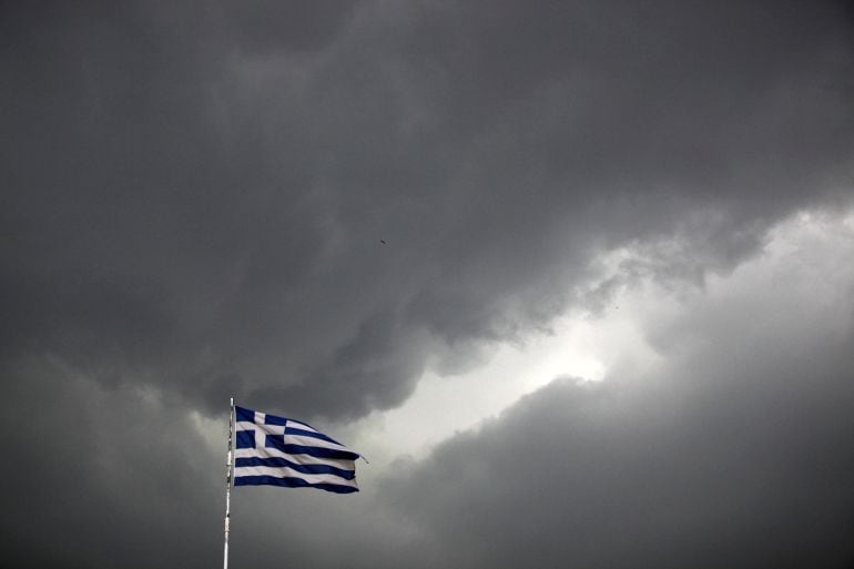 A Greek national flag flutters atop a building as dark clouds fill the sky in Athens, Greece, June 30, 2015. Greece&#039;s conservative opposition warned on Tuesday that Sunday&#039;s vote over international bailout terms would be a referendum over the country&#039;s future in Europe, and that wages and pensions would be threatened if people were to reject the package.    REUTERS/Alkis Konstantinidis 