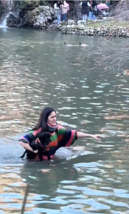 La mujer con su perra entre los brazos saliendo del estanque de El Retiro.