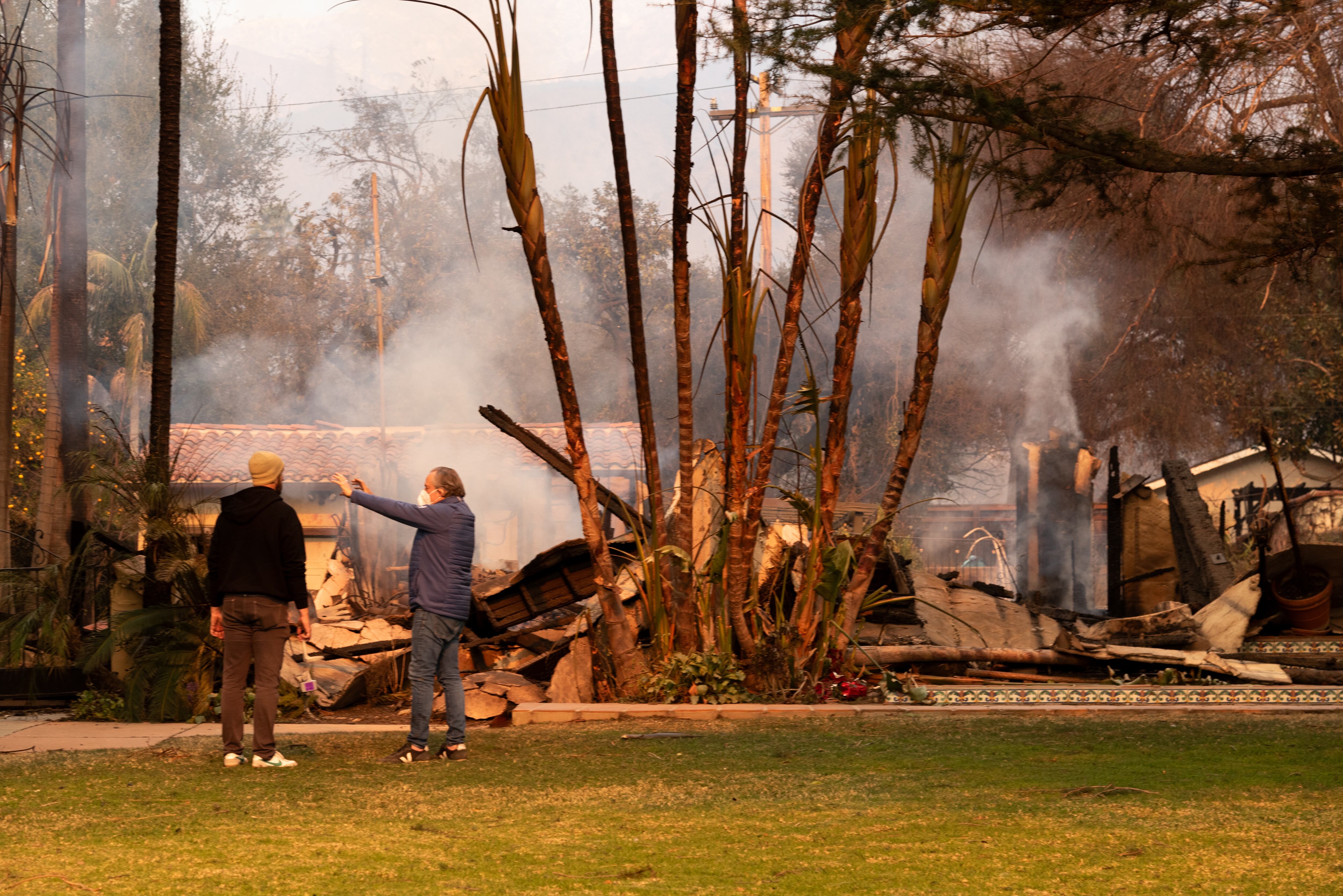 Personas observan una casa afectada por un incendio en Altadena, California (Estados Unidos). EFE/ Ana Milena Varón