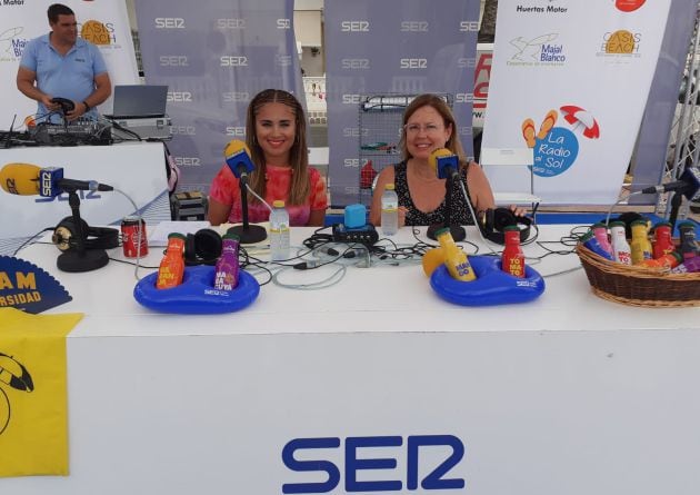 La alcaldesa, Visitación Martínez, y la conductora de La Radio Al Sol, Nazaret Navarro, en el set de la cadena SER situado en la playa de La Puntica, en Lo Pagán (San Pedro del Pinatar)