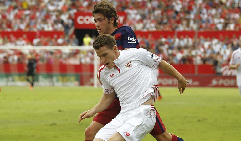 GRA149. SEVILLA, 03/10/2015.- El delantero francés del Sevilla Kevin Gameiro (i) disputa un balón con el centrocampista del FC Barcelona Sergi Gameiro (d), durante el partido frente al Sevilla de la séptima jornada de la Liga de Primera División que se juega hoy en el estadio Ramón Sánchez-Pizjuán. EFE/Paco Puentes