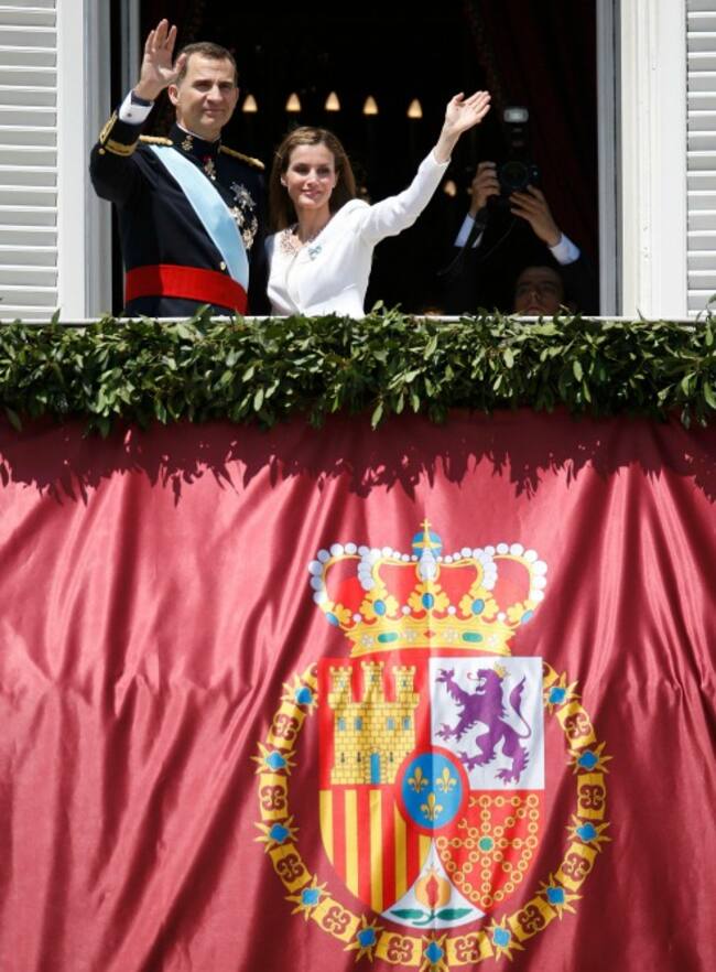 Los reyes de España saludan desde el balcón del Palacio Real.