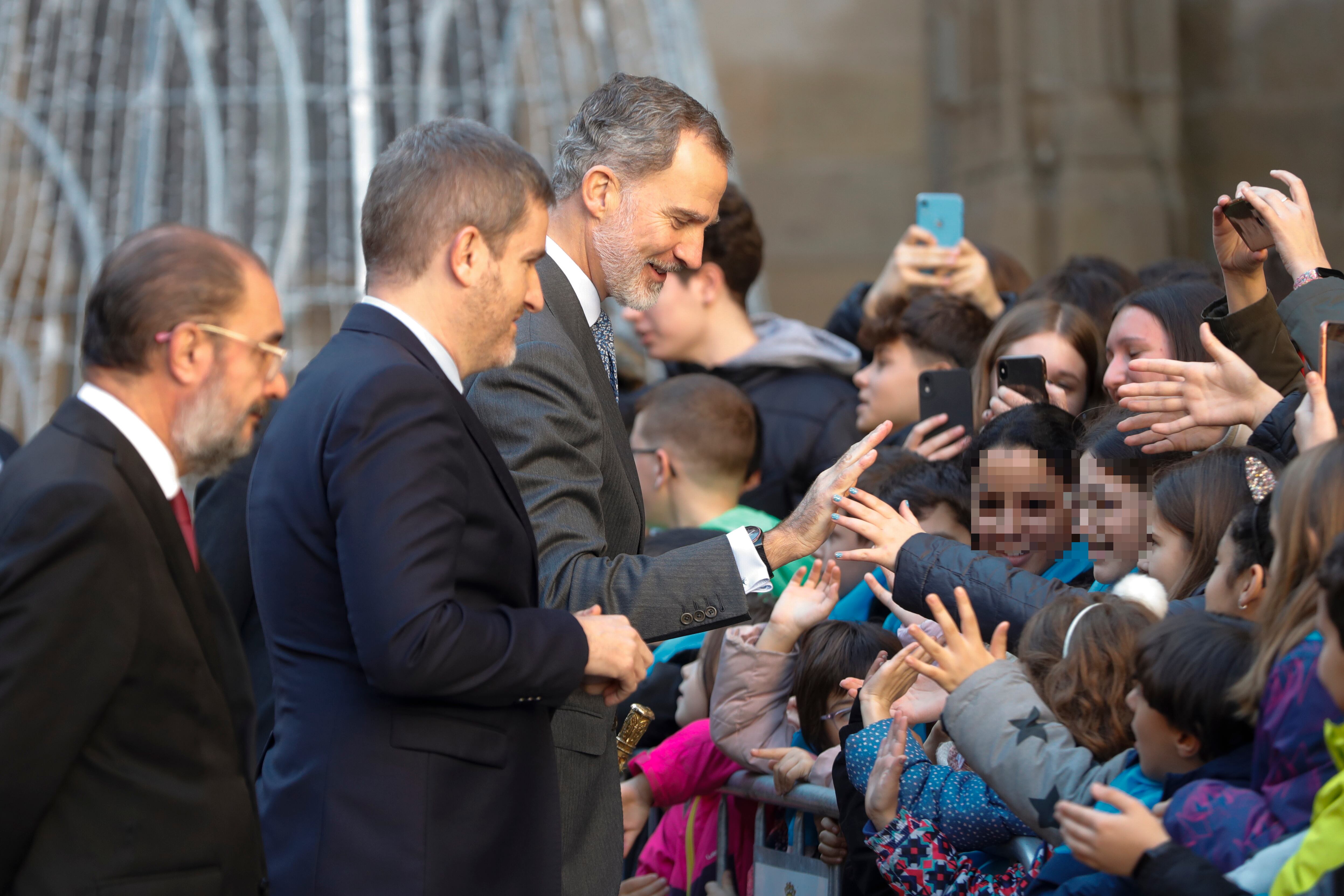 El rey Felipe junto al alcalde de Alcañiz, Ignacio Urquizu (2i), saludan tras la inauguración de la exposición de artistas visuales &quot;De territorios 5x50&quot; en el marco de los actos de conmemoración del cincuentenario de la Uned, este miércoles en Alcañiz. EFE/ Javier Cebollada