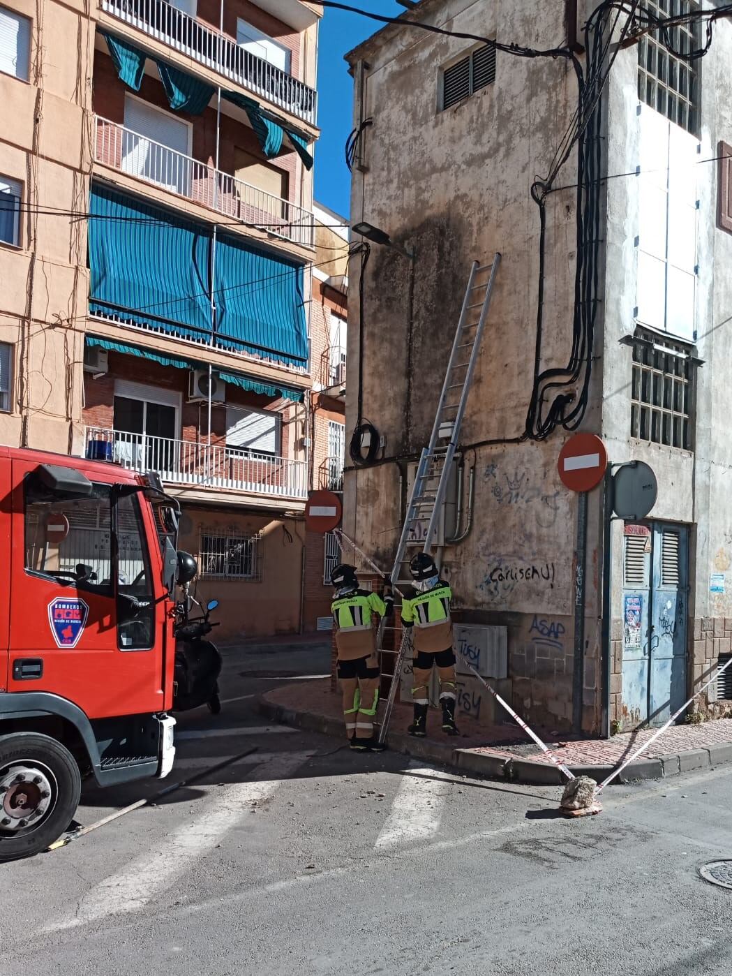 Imagen de bomberos del CEIS en el saneamiento de una fachada, este mediodía, en Alcantarilla