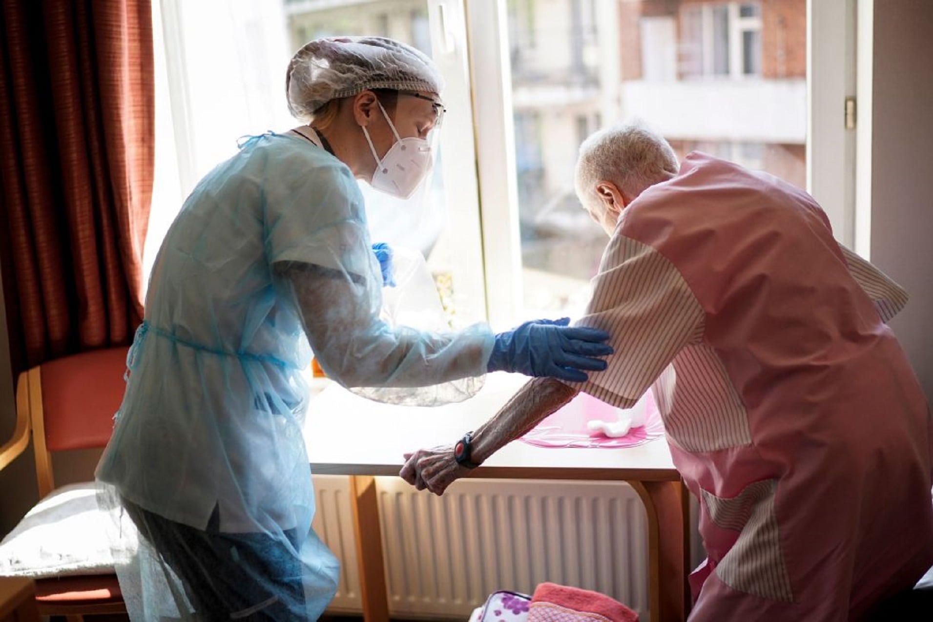 Sanitaria ayudando a anciano