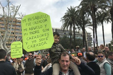 Un abuelo y su nieto portan una pancarta durante la concentración.