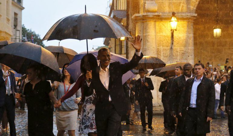 El presidente de Estados Unidos, Barack Obama, pasea con su familia bajo la lluvia por Habana Vieja.