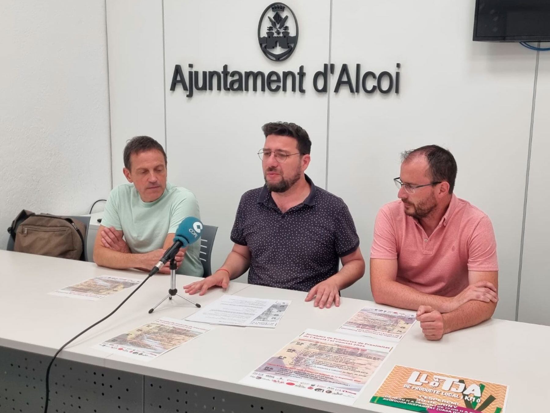 Tono Belda, coordinador cultural del Campus d'Alcoi de la UA, junt al regidor de Comerç, Aleixandre Cerradelo, i el gerent de la Mancomunitat, Luis Mullor, durant la presentació de les jornades