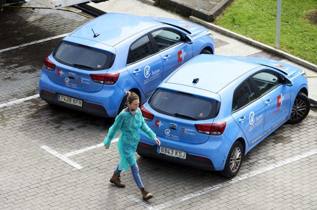 Una profesional sanitaria pasa al lado de vehículos de hospitalización domiciliaria del Hospital Universitario Marqués de Valdecilla, donde el pasado lunes 16 de marzo se registró la primera muerte de un paciente con coronavirus de Cantabria, un hombre de 88 años con patología previa, en Santander Juan Manuel Serrano Arce