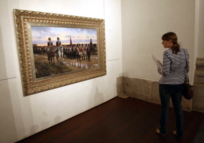 Una espectadora de la exposición &quot;Soldados de España en la Historia&quot; contempla una de las obras