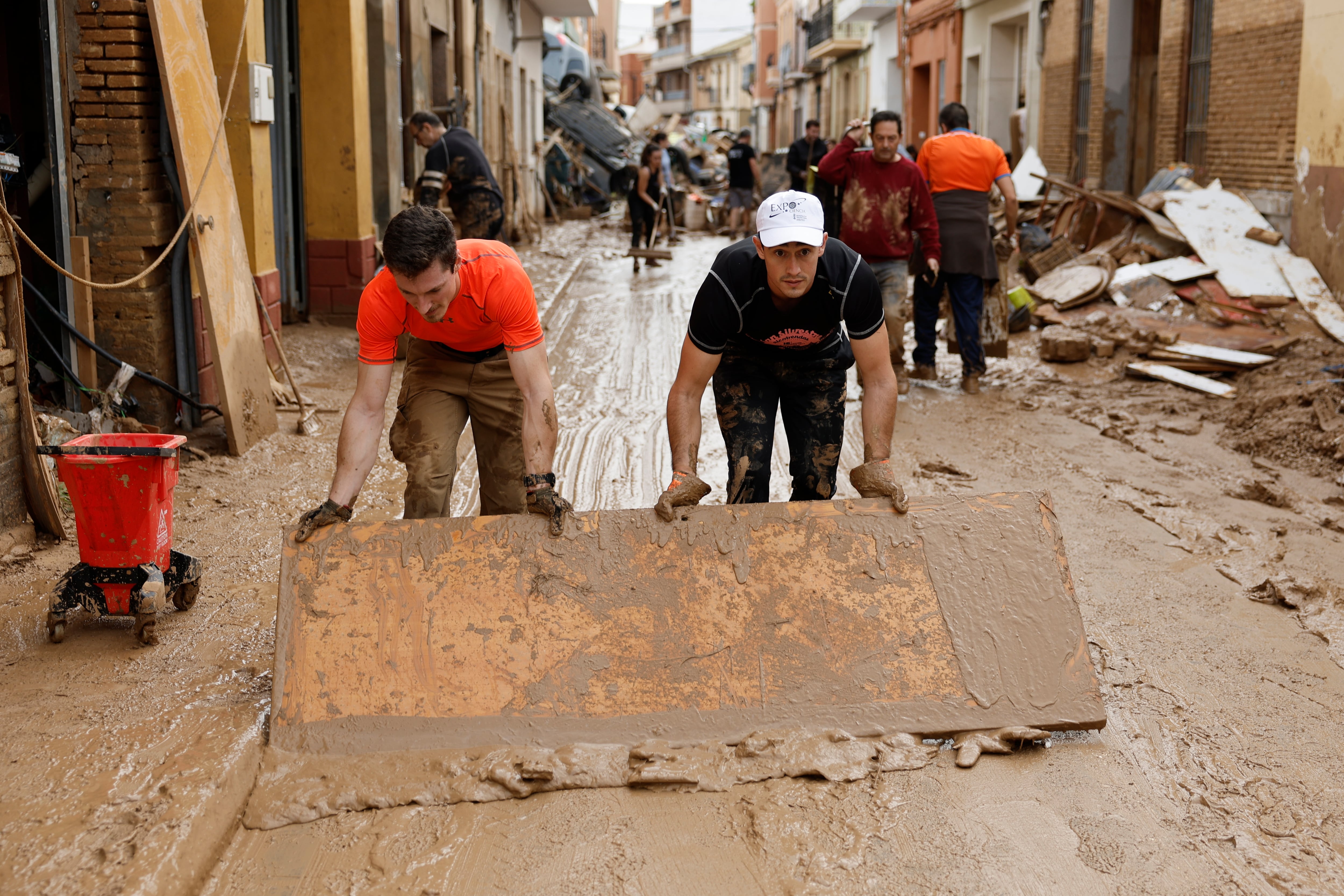 PAIPORTA, 01/11/2024.- Vecinos de Paiporta limpian el lodo de una calle afectada, este viernes. Las víctimas mortales en la provincia de Valencia a causa de la devastadora dana ha aumentado este viernes hasta las 202, según el último recuento facilitado por el Centro de Emergencias de la Generalitat Valenciana. EFE/Biel Aliño
