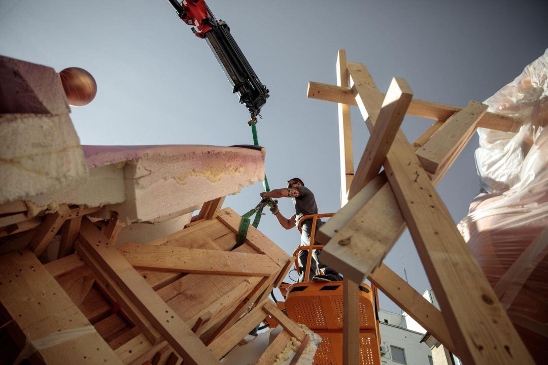 Un operario trabaja en el desmontaje de la falla de El Pilar, tras el aplazamiento "sine die" de las Fallas a causa de la epidemia del coronavirus, con la incógnita principal de quién asumirá los enormes costes que acarreará el desmontaje de los monumentos ya plantados y la suspensión de cientos de actos festivo.