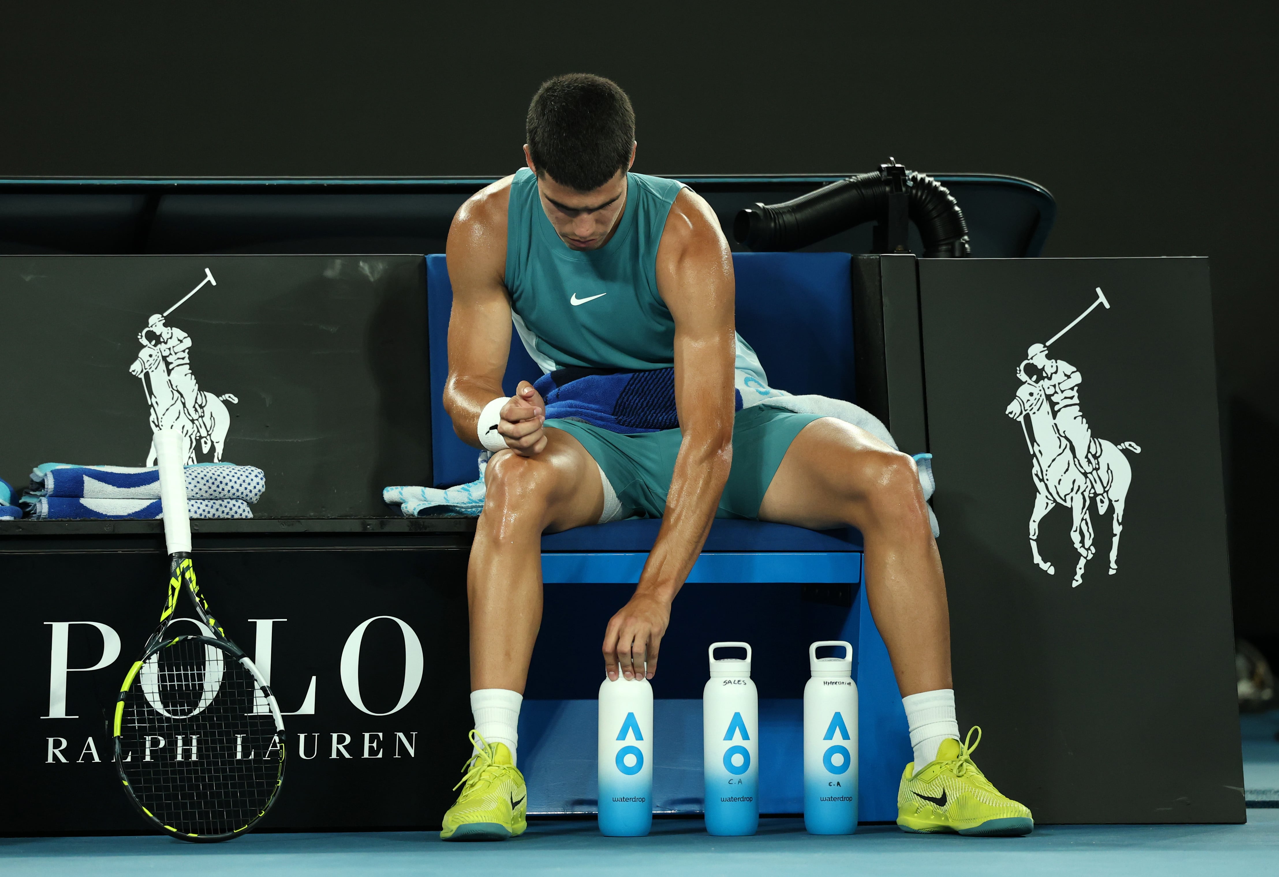 Carlos Alcaraz coloca sus botellas de agua en el Open de Australia durante su partido ante Novak Djokovic