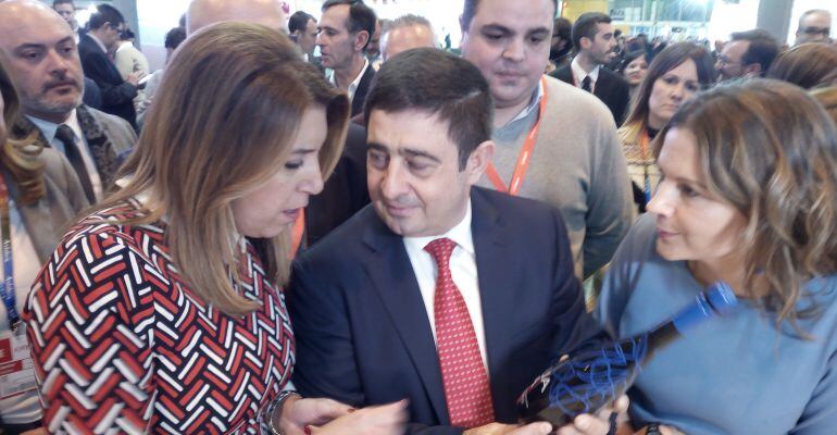 El presidente de la Diputación Provincial de Jaén, Francisco Reyes, conversa con la presidenta de la Junta de Andalucía, Susana Díaz, y con la delegada del Gobierno andaluz, Ana Cobo, con una botella de AOVE Picualia en la mano.
