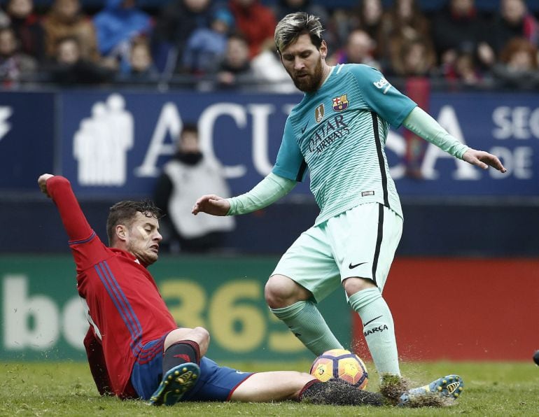 Lionel Messi protege el balón ante Oriol Riera