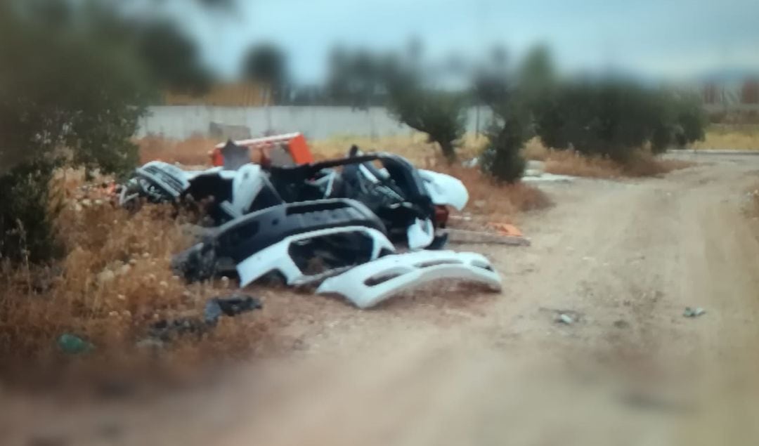 Paragolpes en una zona de cultivo depositados, presuntamente, por el dueño de un taller cercano.