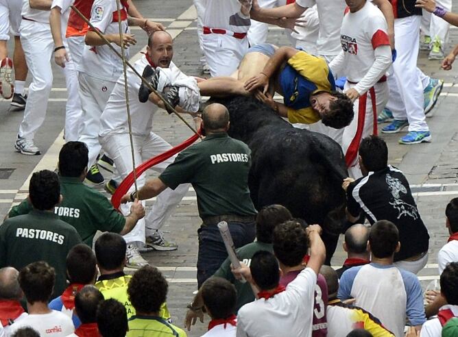 Un joven es empitonado en la calle Estafeta durante el sexto encierro de los sanfermines donde los toros de la ganadería del Pilar (Salamanca) han protagonizado un peligrosísimo y largo sexto encierro