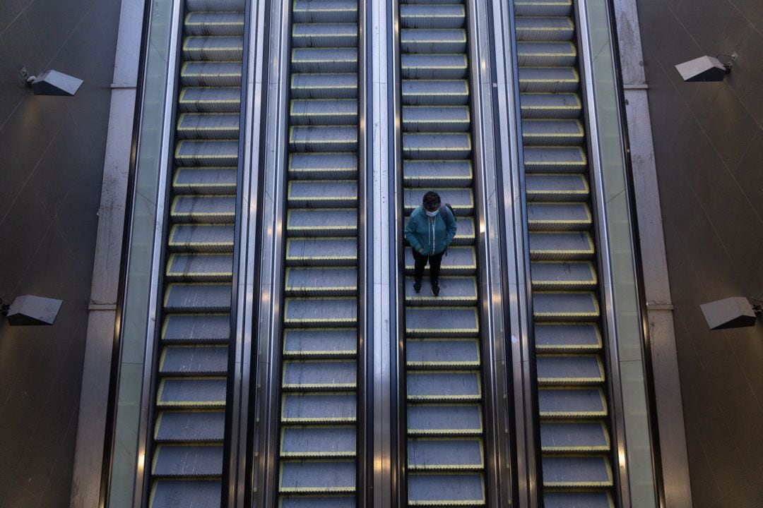 Una mujer baja las escaleras del metro de Santiago, en el primer día de una cuarentena total para combatir la propagación del coronavirus